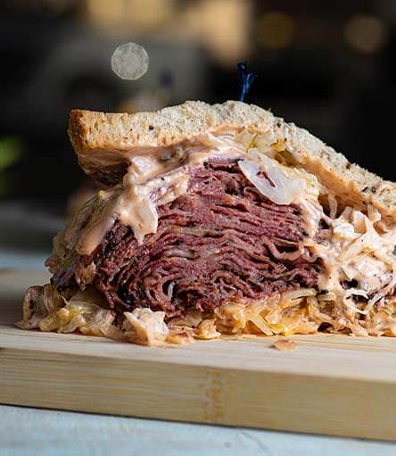 Messy Pastrami Sandwich on a Wood Block