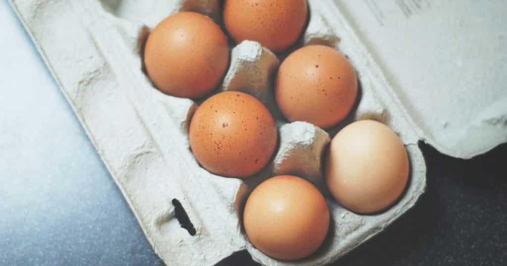 eggs in an open carton sitting on a table